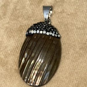 Pendant with grey and clear crystals piece of a shell has a silver tone bale